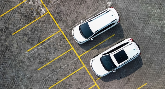 PXL_20230507_142535864 aerial view of two cars parked directly next to each other in empty car park