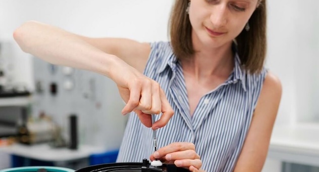 Female engineer adjusting noise filter with a fine screwdriver