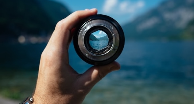 PXL_20230507_142535864 Hand holds lens up to a view of a lake and mountains