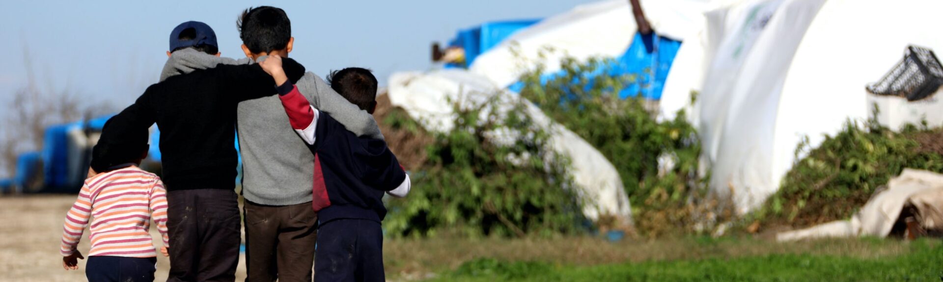 Refugee children hug each other in camp