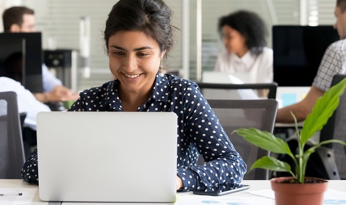Indian worker reading message looking at computer screen